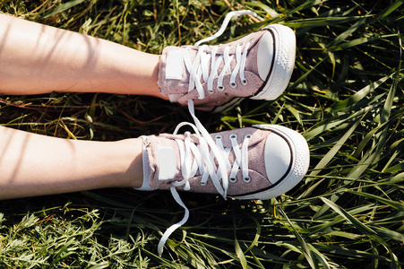 在草地上的女孩腿紫色运动鞋照片