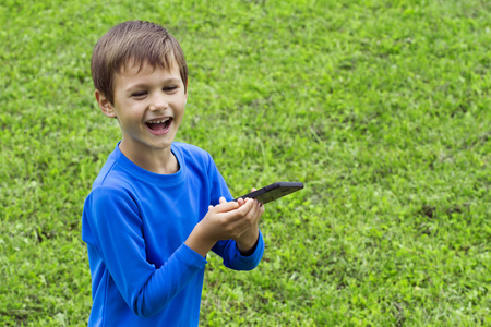 儿童与室外自然的移动电话。童年 科技 休闲概念图片