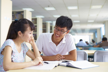青年大学生在图书馆一起学习照片
