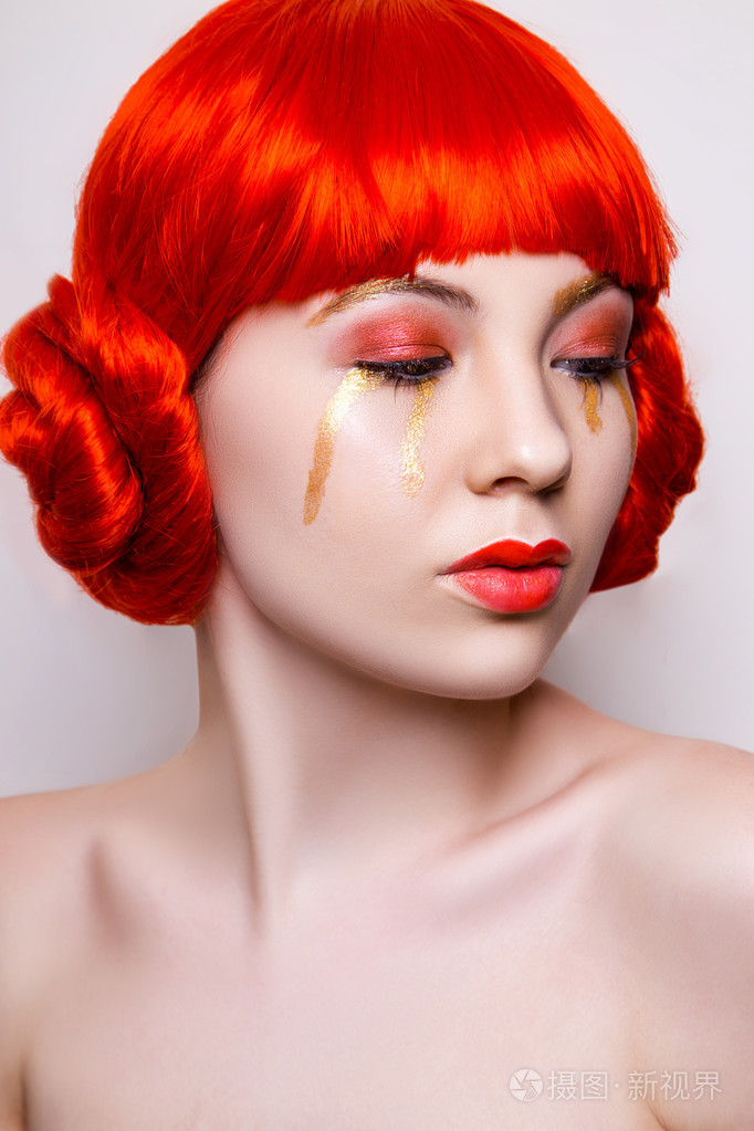 穿着红色和金色时尚的女人化妆,红色的头发在白色的背上