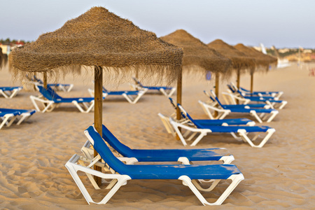 图像与遮阳伞和沙滩上休闲椅图片