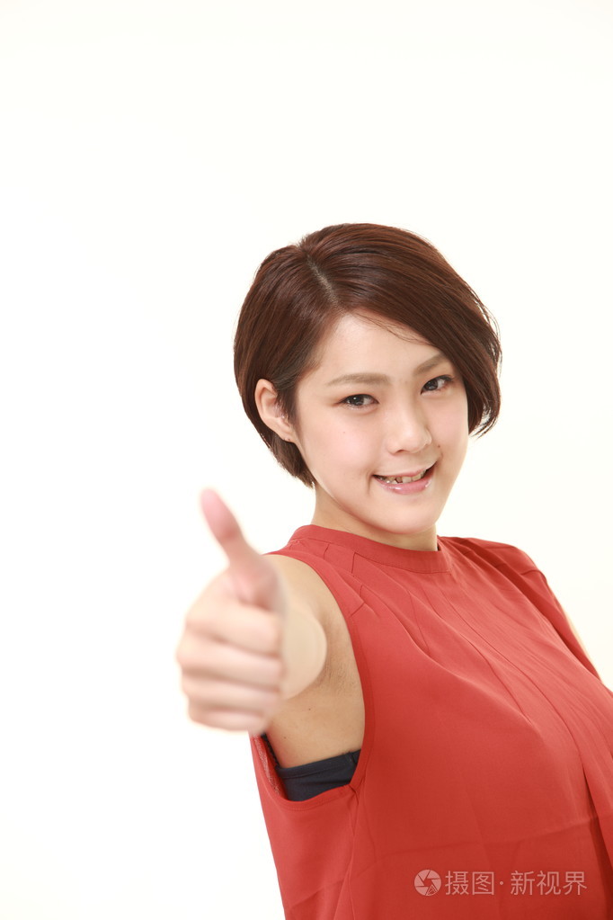 日本年轻女性与手势竖起大拇指