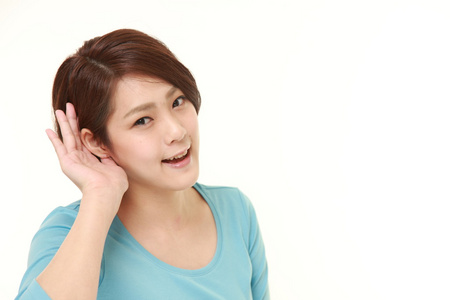 年轻女子用手仔细的倾听的耳朵后面照片