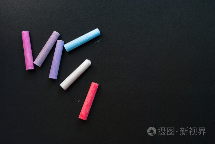 分散的学校蜡笔粉笔黑色木制表面