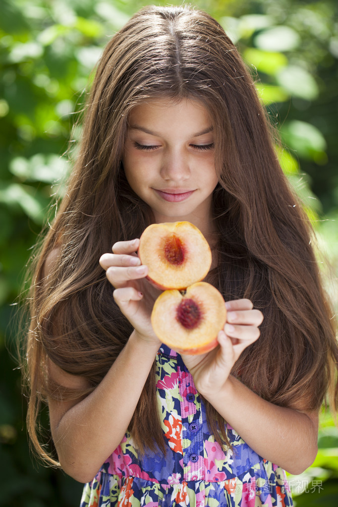 一个年轻的黑发小女孩与桃子的肖像