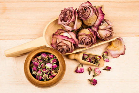 干玫瑰和花蕾与木制物体