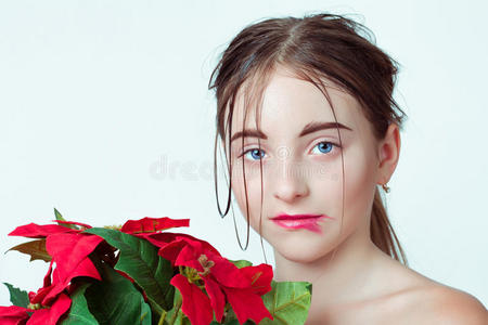 年轻女孩的美丽肖像。 早上的形象与湿脸的效果。 手里拿着一朵红花的女孩。
