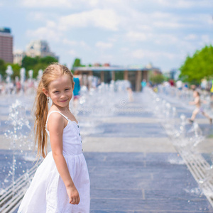 快乐的小女孩在街上的喷泉里玩得很开心