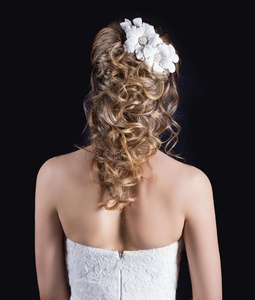 美丽的年轻女孩在新娘的形象，美丽的婚礼发型与花在她的头发，发型为新娘