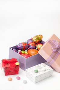 复活节巧克力和鸡蛋在粉红色的盒子在白色的背景