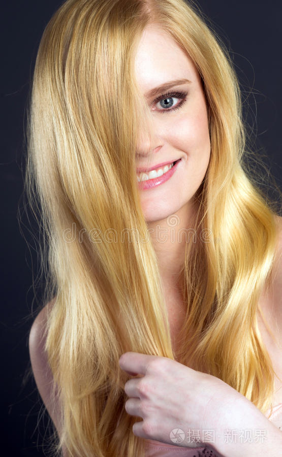 美丽微笑的金发女人梳着头发