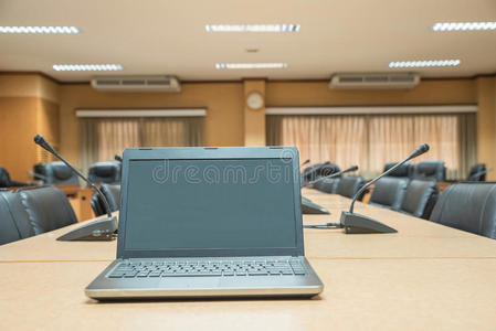 在会议之前，笔记本电脑在会议室的空椅子前面