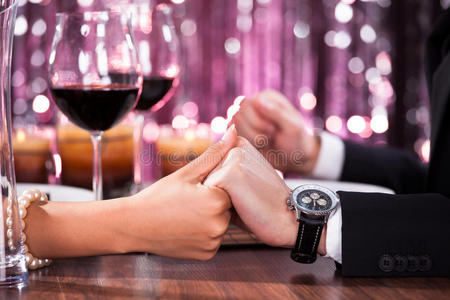 一对夫妇在吃饭时互相牵手照片