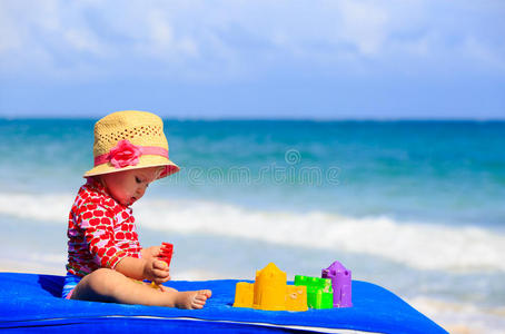 可爱的小女孩在海滩上玩沙玩具