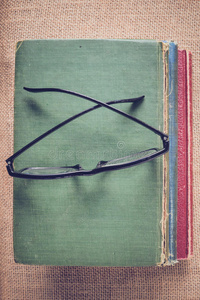 书籍和阅读眼镜的老式麻布背景与Inst