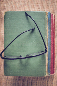 书籍和阅读眼镜的老式麻布背景与Inst