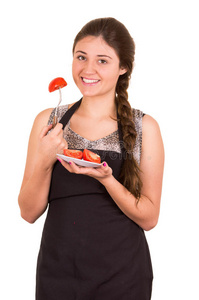 美丽的年轻女孩吃新鲜的西红柿