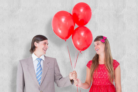 微笑的极客夫妇拿着红色气球的复合图像