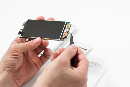 修理工用镊子拆卸智能手机照片