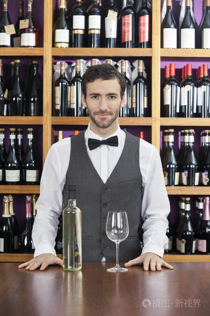 有信心酒保与白葡萄酒站柜台
