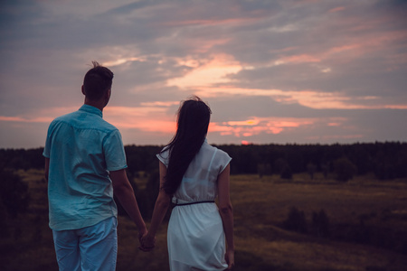 爱情故事.在爱的情侣走在夕阳的背景.剪影数字性质热恋中的人.