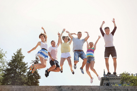 快乐少年跳跃一群快乐的青少年在街上跳跃照片