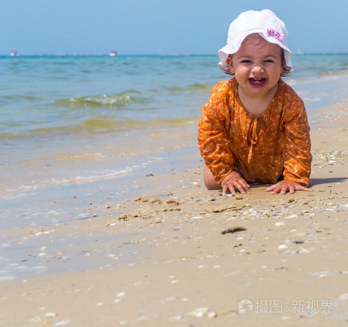 漂亮的小女孩爬上海滩，快乐的小孩，情感