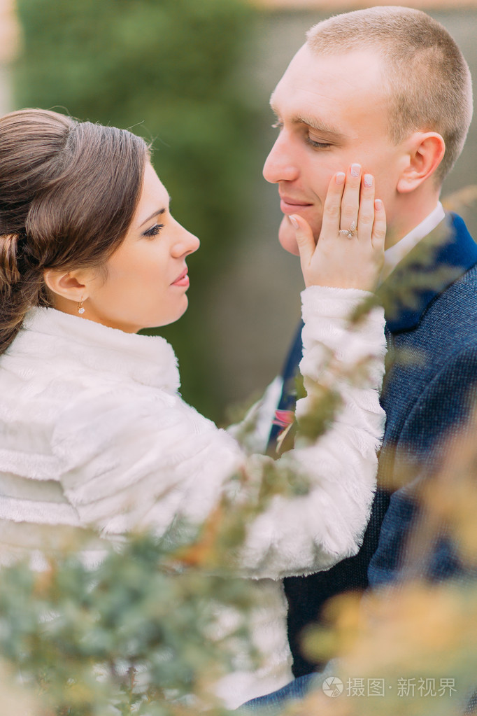 幸福的新婚夫妇,温柔新娘和英俊的新郎,在婚礼上走在美丽的绿色公园