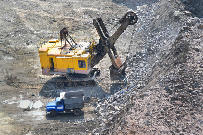 巨大的挖掘机和一辆卡车上花岗岩采石场