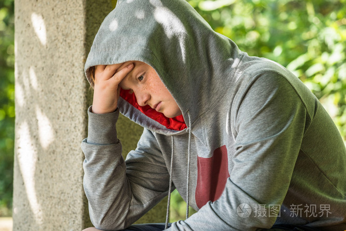 不愉快的男孩坐在公园