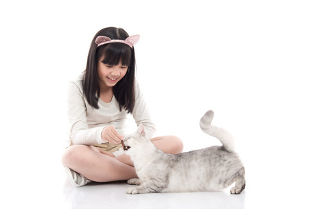 美丽的亚洲女孩给可爱的小猫喂零食照片