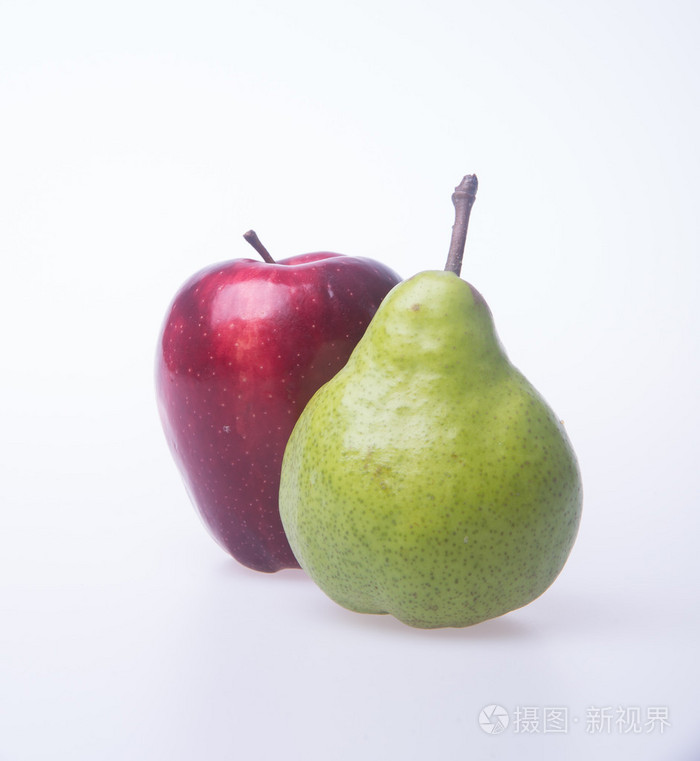 红红的苹果和背景上的绿色梨子