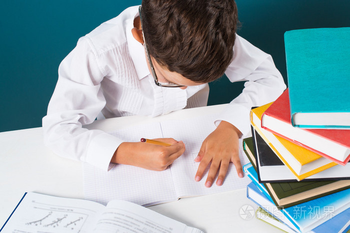 忧郁可爱的男孩坐在做家庭作业