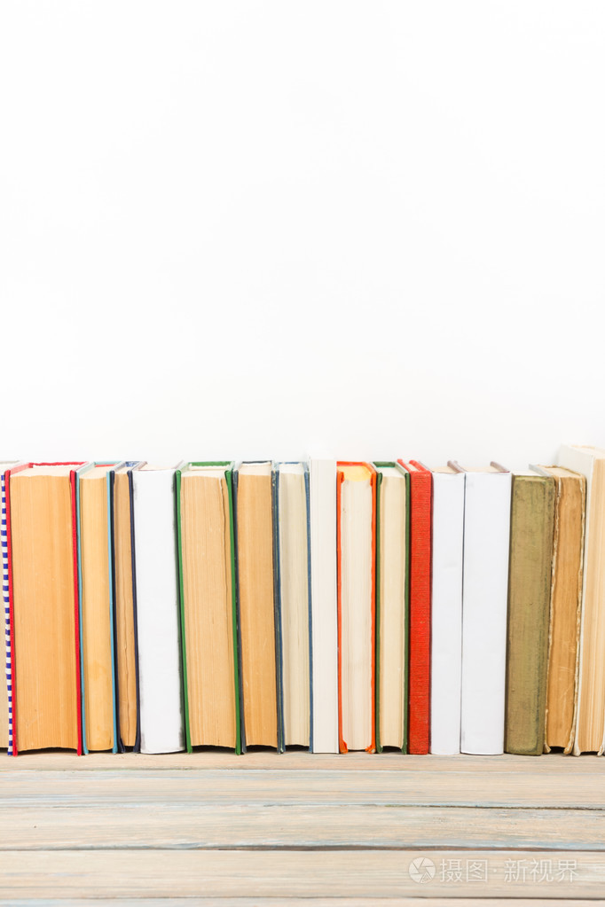 照片 在图书馆的 grunge 木桌书桌书架上的书.