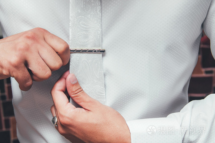 放领带夹,特写的白衬衫的男人