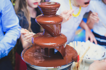 充满活力的巧克力喷泉,在孩子们的生日聚会上照片