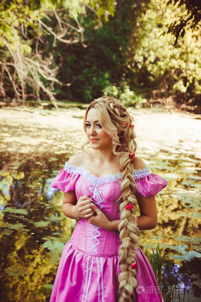 长长的头发编织在一条辫子,站在湖边的漂亮女孩照片-正版商用图片1pin