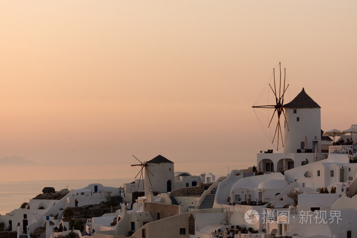 锡拉 基克拉迪伊亚镇和圣托里尼岛的全景图的白色风车惊人落日