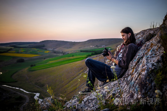 坐在岩石上的帅气男模特