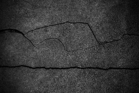 裂纹粗糙沥青的背景的纹理照片