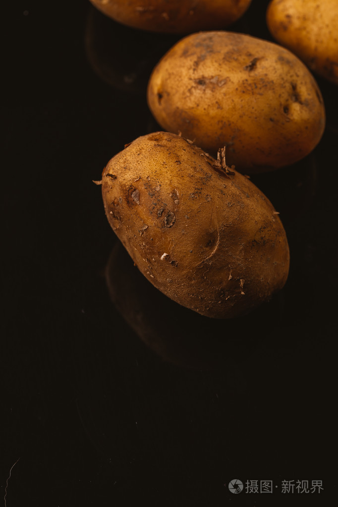 在黑色背景上的新鲜原料土豆