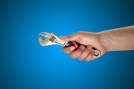 男人的手拿着大扳手照片