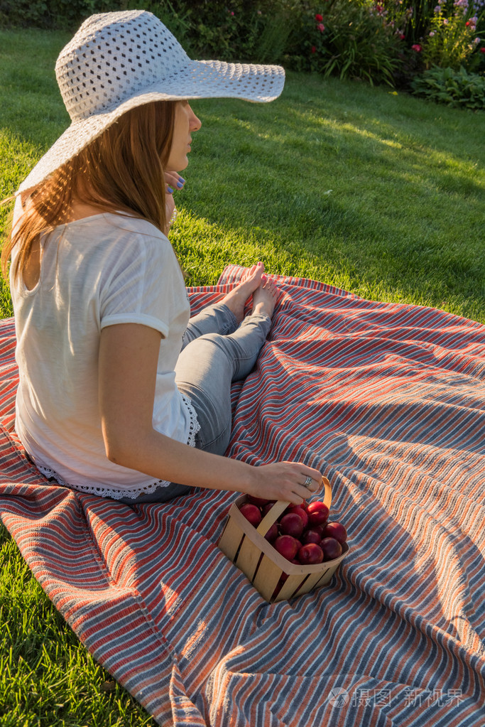 年轻的女孩坐在草地上