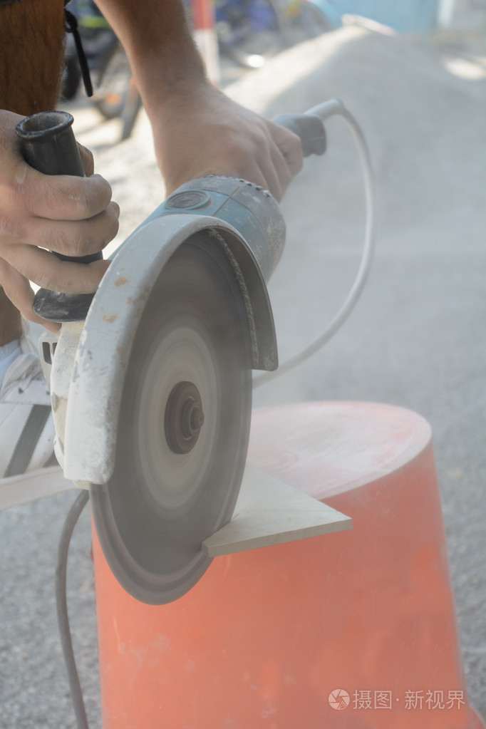 工人用角磨机切割瓷砖