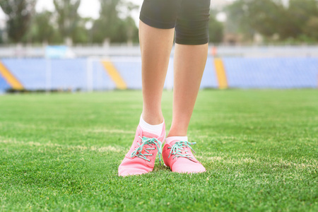 女人穿着粉红色运动鞋和站在草地上照片