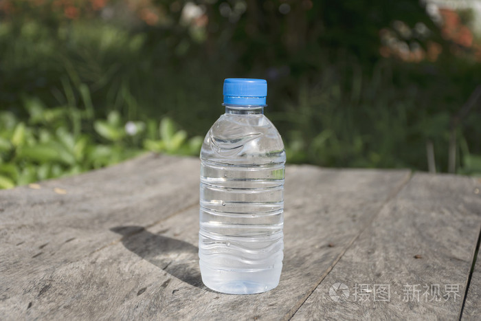 与自然背景的木桌上的矿泉水瓶