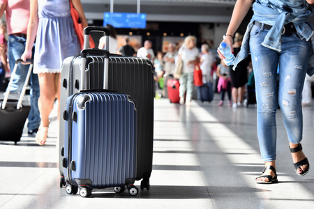 两个塑料旅行行李箱在机场大厅照片