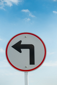 左左转车道通行在天空背景上的左转交通标志照片