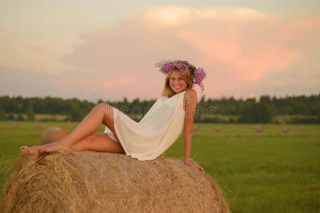 在日落时分在田野上摆姿势的金发女人