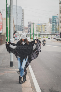 美丽的年轻黑发女郎在城市街道上摆姿势